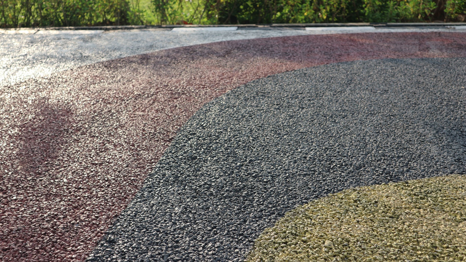 Black asphalt. Pebble stone flooring with epoxy resin in city park. Pebble stone is yellow and red.